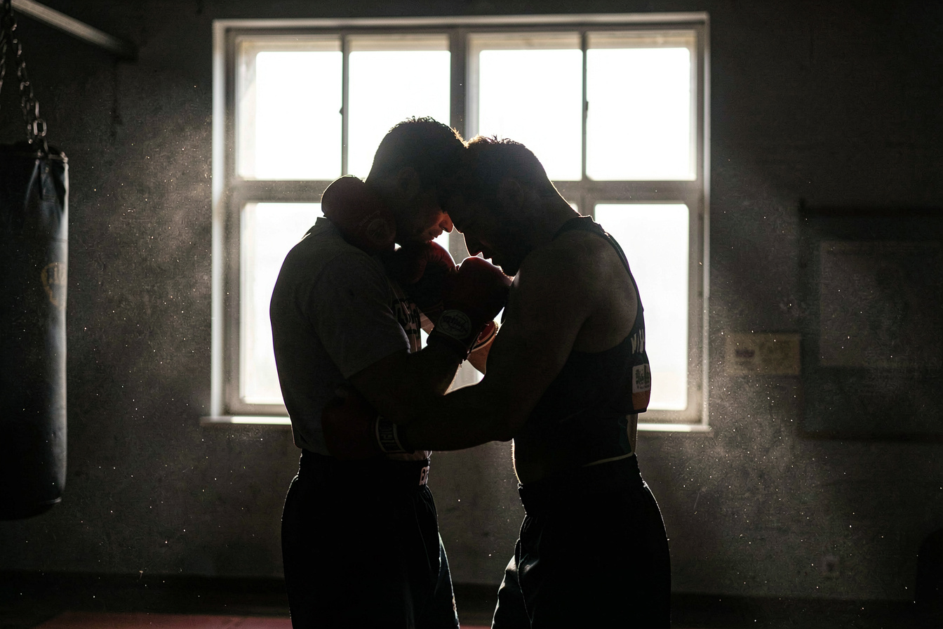 Twee silhouetten in de clinch tegen een fel raam